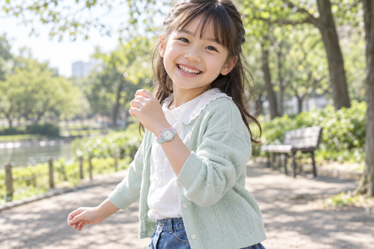 ストロベリーミントの腕時計を着け、ミントのカーディガンで公園を楽しむ笑顔の女の子（AI生成イメージ）