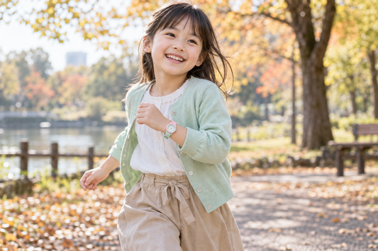 ストロベリーミントの腕時計にミントのカーディガンを合わせ、秋の公園を歩く女の子（AI生成イメージ）
